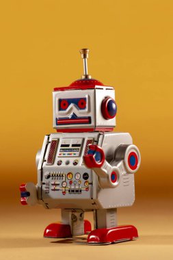 Sarı bir arka plan üzerinde yalıtılmış bağbozumu Teneke robot oyuncak.