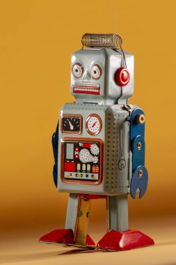 Sarı bir arka plan üzerinde yalıtılmış bağbozumu Teneke robot oyuncak.