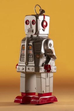 Sarı bir arka plan üzerinde yalıtılmış bağbozumu Teneke robot oyuncak.