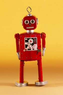 Sarı bir arka plan üzerinde yalıtılmış bağbozumu Teneke robot oyuncak.