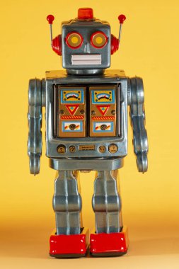 Sarı bir arka plan üzerinde yalıtılmış bağbozumu Teneke robot oyuncak.