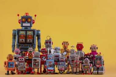 Sarı bir arka plan üzerinde izole vintage Teneke robot oyuncaklar.