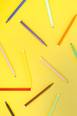 sarı bir arka plan üzerinde izole keçeli kalem kümesi.