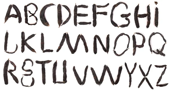 字母表与角豆水果荚查出的白色背景 — 图库照片