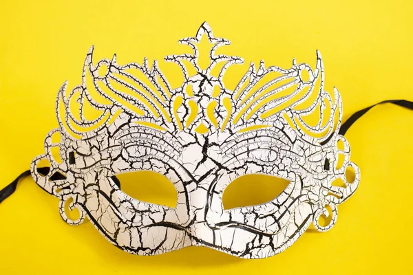 white venetian mask isolated on a yellow background.