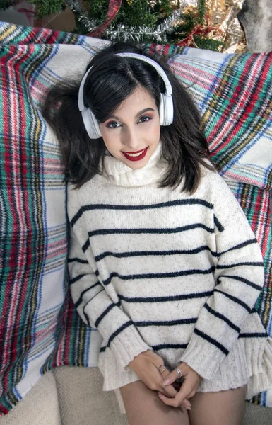 Chica joven en el sofá con auriculares — Foto de Stock