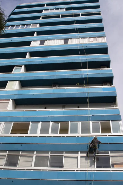 Man cleans windows on highrise — Stock Photo, Image