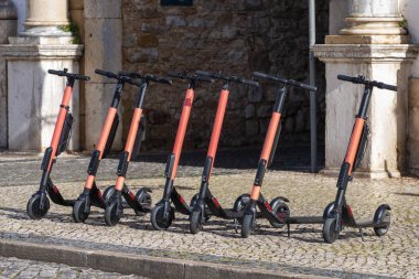 Sokakta arka arkaya elektrikli scooter.