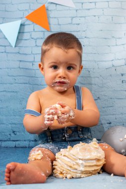 Balonlardan, kurdelelerden, tuğla duvar kâğıdından ve kreplerden oluşan bir seti olan bir yıllık erkek bebek için parti..