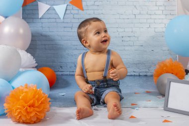 Balonlardan, kurdelelerden ve duvar kağıdından oluşan bir set ile bir yıllık erkek bebek için parti..