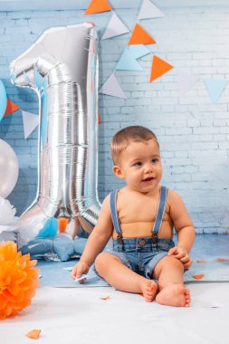 Balonlardan, kurdelelerden ve duvar kağıdından oluşan bir set ile bir yıllık erkek bebek için parti..