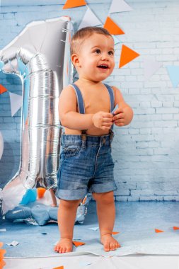 Balonlardan, kurdelelerden ve duvar kağıdından oluşan bir set ile bir yıllık erkek bebek için parti..