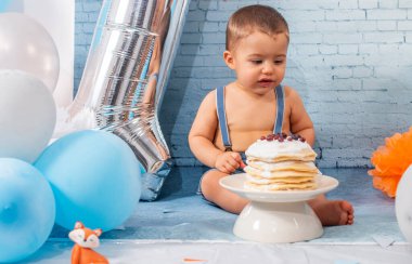 Balonlardan, kurdelelerden, tuğla duvar kâğıdından ve kreplerden oluşan bir seti olan bir yıllık erkek bebek için parti..