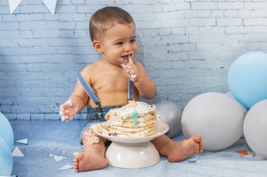 Balonlardan, kurdelelerden, tuğla duvar kâğıdından ve kreplerden oluşan bir seti olan bir yıllık erkek bebek için parti..