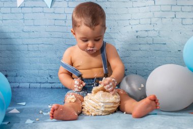 Balonlardan, kurdelelerden, tuğla duvar kâğıdından ve kreplerden oluşan bir seti olan bir yıllık erkek bebek için parti..