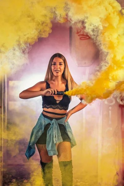 街の雰囲気の中でファッションでポーズ楽しい創造的な方法でカラフルな煙手榴弾を操縦女の子 — ストック写真