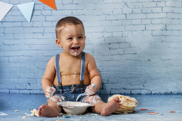 Party for one year baby boy with a set composed of ribbons, and brick wall paper and pancakes.