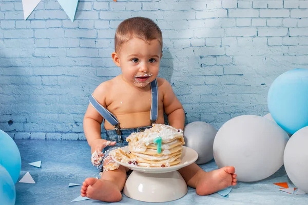 Party for one year baby boy with a set composed of balloons, ribbons, and brick wall paper and pancakes.