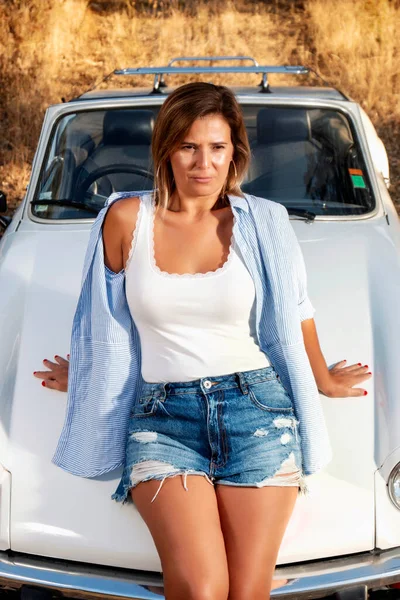 田舎で白いコンバーチブルヴィンテージ車と女性 ファッショナブルなライフスタイルをポーズで — ストック写真