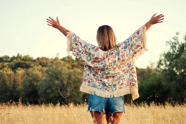 美しいです女の子ポージングオンザ田舎とともに短いジーンズ上の乾燥した草の植生 — ストック写真