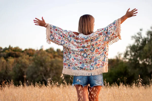 美しいです女の子ポージングオンザ田舎とともに短いジーンズ上の乾燥した草の植生 — ストック写真