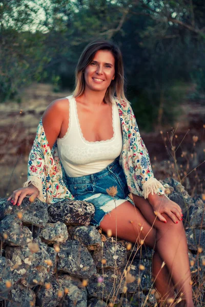 Hermosa Chica Posando Campo Con Vaqueros Cortos Sentados Una Pared —  Fotos de Stock