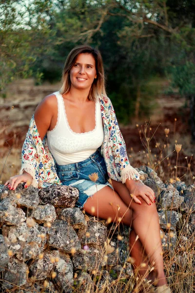 Hermosa Chica Posando Campo Con Vaqueros Cortos Sentados Una Pared —  Fotos de Stock