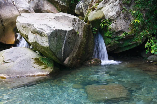 Little waterfall among the rocks in a mountain forest