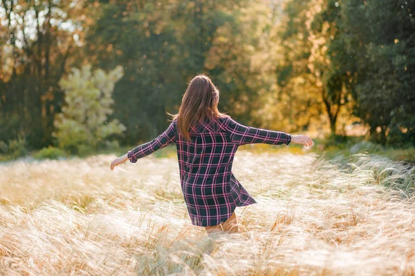 Belle jeune fille marchant au coucher du soleil — Photo