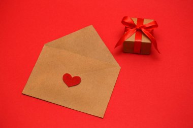 Sevgililer günü, 14 Şubat kırmızı kalp kırmızı bir arka plan üzerinde bir zarf içinde sonraki bir hediye tatil kavramı bir kırmızı kurdele ile bağlanmış bir paket için