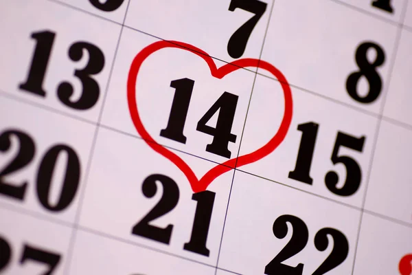 Valentines Day and the concept of holidays - close-up of a calendar sheet with the date February 14th marked with a red heart-shaped