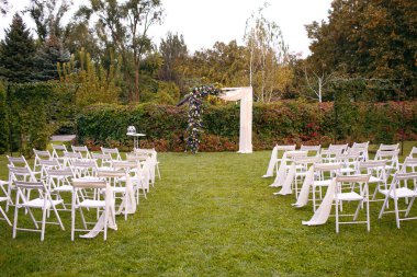 Düğün. Töreni. Arch düğün. Nehir kıyısında yeşil çimlerde düğün kemer şubeleri, çiçek ve yeşillik yapılmış açıktır.