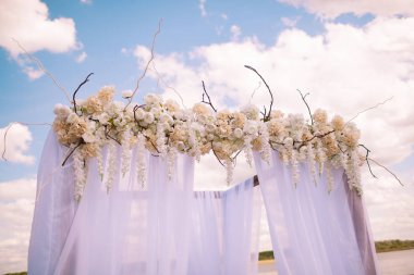 Düğün. Töreni. Arch düğün. Yeşil çimenlerin üzerinde gökyüzü Nehri'nin üzerinde kemer şube, çiçek ve yeşillik düğün duruyor.