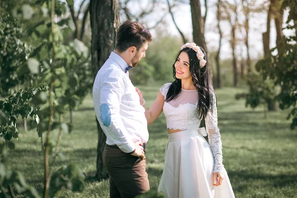 Romantische gevoelens in het veld bij zonsondergang, de bruidegom kijkt naar de bruid, het meisje houdt van zijn vriendje — Stockfoto