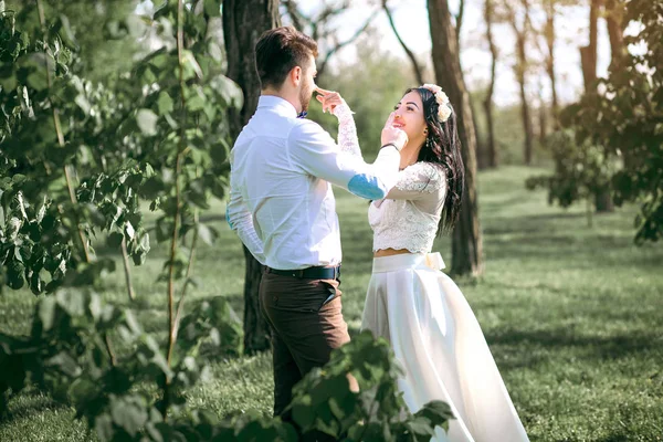 Pareja de boda, la novia se ríe con el novio, el chico con las bromas de chica, puesta de sol, una novia hermosa y un novio con estilo — Foto de Stock