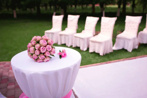 En vacker bröllop bukett pion rosor, lögner på ett vitt bord, allt är klart för vigseln, vackra rosa pioner — Stockfoto