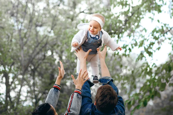 Famille heureuse en plein air activité, père élève bébé, rire et jouer, père montre à la mère comment jeter bébé en toute sécurité — Photo