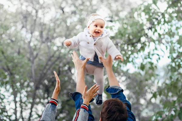 Famille heureuse en plein air activité, père élève bébé, rire et jouer, père montre à la mère comment jeter bébé en toute sécurité — Photo