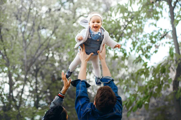 Famille heureuse en plein air activité, père élève bébé, rire et jouer, père montre à la mère comment jeter bébé en toute sécurité — Photo