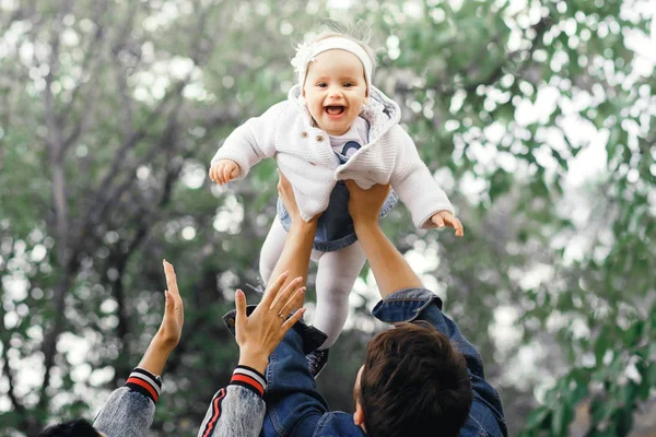 Famille heureuse en plein air activité, père élève bébé, rire et jouer, père montre à la mère comment jeter bébé en toute sécurité — Photo