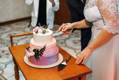 Gelin ve Damat Düğün düğün pastası kesti, pastayı çiçeklerle süslüdür