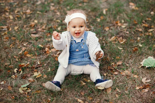 Happy little baby boy sitting on the grass in the park, garden, meadow. Baby looks at parents, beautiful warm weather — Stock Photo, Image