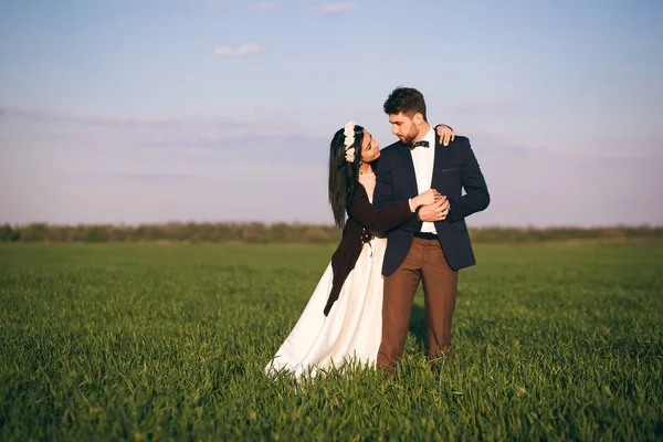 Meisje en jongen knuffelen in het veld, de koude avond, het meisje in een gebreide trui, de zachte en liefdevolle jongeren, de bruid en de bruidegom — Stockfoto