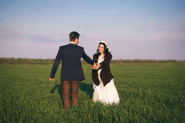 Ragazza e ragazzo che si abbracciano nel campo, sera fredda, ragazza in un maglione a maglia, giovani gentili e amorevoli, sposa e sposo — Foto Stock