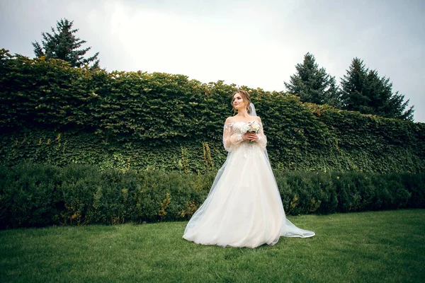 Schöne Schlanke Braut Steht Auf Einem Hintergrund Aus Grünem Efeu — Stockfoto