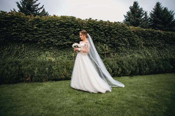 Schöne Schlanke Braut Steht Auf Einem Hintergrund Aus Grünem Efeu — Stockfoto
