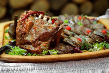 Ateşle pişirilmiş ahşap tepside çeşitli etler, salata ve acı biberli biftekler, bir restoran yemeği, kütüklerin arka planı, büyük bir şirket için bir sürü et.