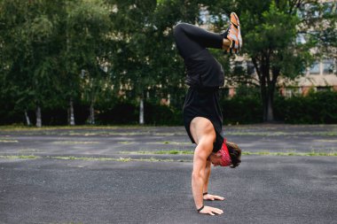 Erkek atlet baş aşağı duruyor, antrenmandan önce ısınma, spor giyim, spor antrenmanı, spor endüstrisi, koşu bandı, güçlü kollar, yazı için yer, yatay fotoğraf.