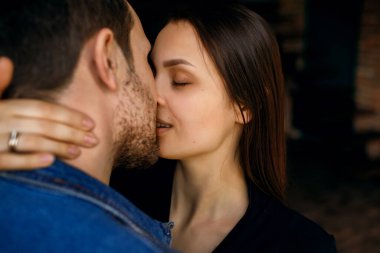 Bir kadın erkeğini öper, nazik bir kucaklama, bir eş kocasına dudaklarıyla dokunur, mesaj için boş alan, bir erkekle bir kız arasındaki aşk ilişkileri, ev ortamı.