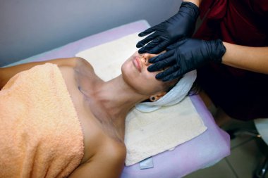 Güzel ve genç bir kadın yüz masajı, cilt bakımı, güzellik merkezinde siyah maske, mesaj atılacak yer, güzellik salonunda işlem yapan kız, vücuduna ve sağlığına dikkat eden kız.